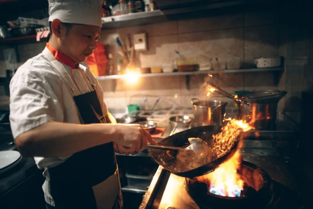 A chef cooks in an Asian restaurant.